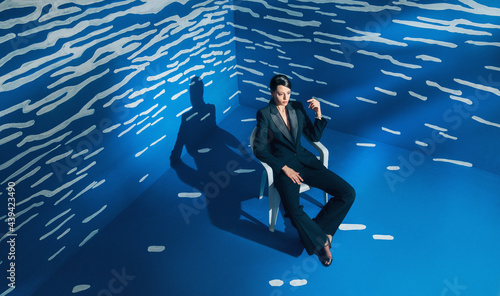 Stylish Fashion Female Model In Front Of The Abstract White And Blue Space.