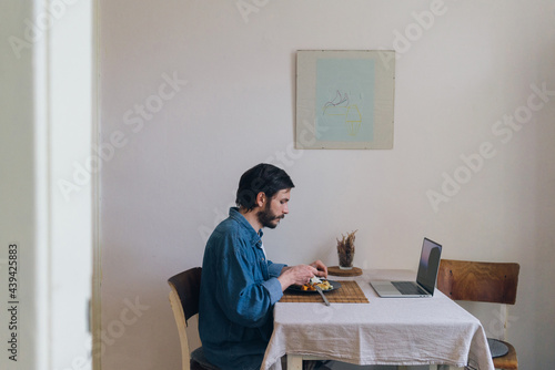Single caucasian man eating a vegetarian lunch in a dining room 