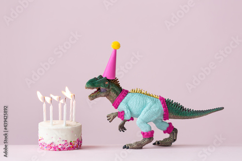 Dinosaur blowing out birthday cake candles photo