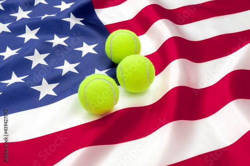 THREE TENNIS BALLS ON THE AMERICAN FLAG. UNITED STATES TENNIS SUCCESS CONCEPT.