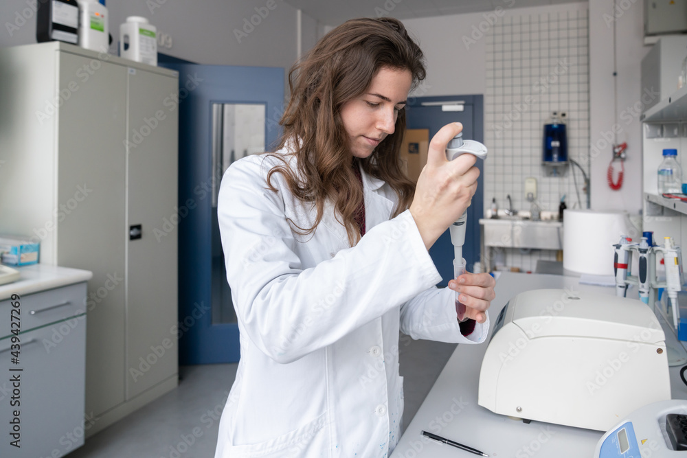 Scientist Using Pipette in Laboratory Scientist Using Pipette in Laboratory