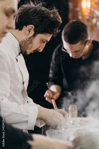 Group of cooks preparing food in restaurant photo