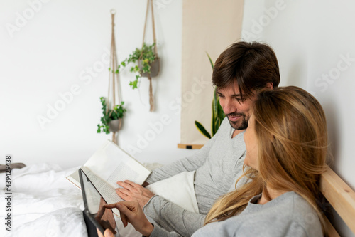 couple in bed reading book together photo