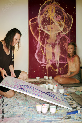 Two girls are engaged in abstract painting