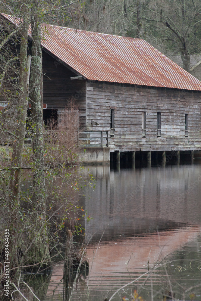 Weathered wooden building with a tin roof over a waterfall Weathered wooden building with a tin roof over a waterfall