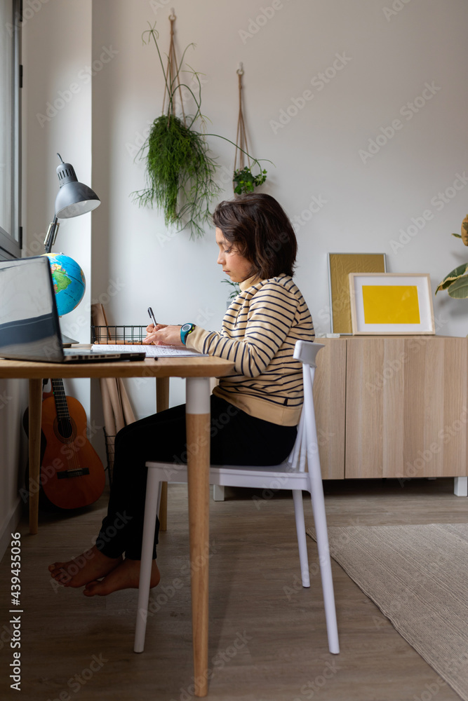 barefoot kid sitting on desk studying barefoot kid sitting on desk studying