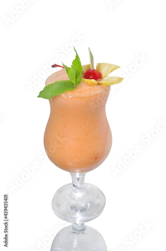 yellow smoothie in glass decorated with mint and cherry isolated on white