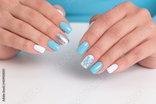 Beautiful female hands with romantic manicure nails  blue and white gel polish