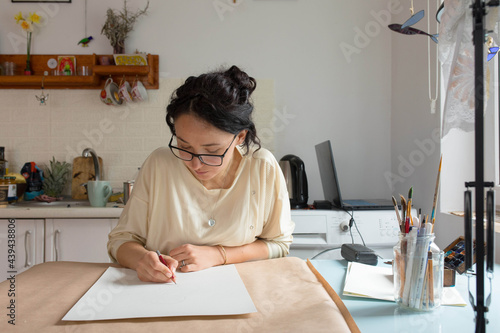 girl 30 years old draws with a pencil
