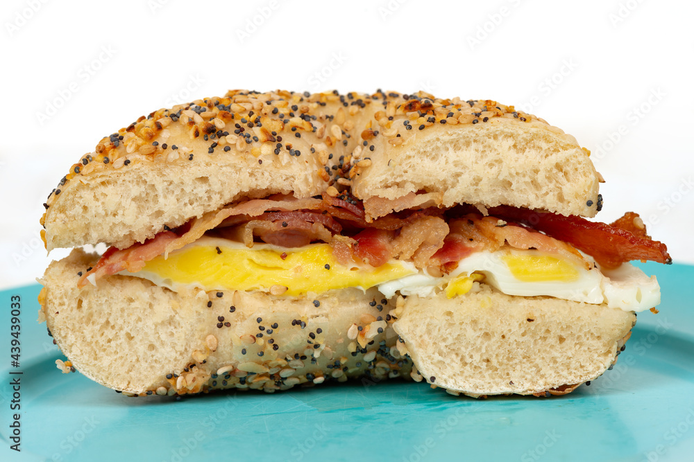 Close up of an everything bagel with bacon and egg isolated on white Close up of an everything bagel with bacon and egg isolated on white