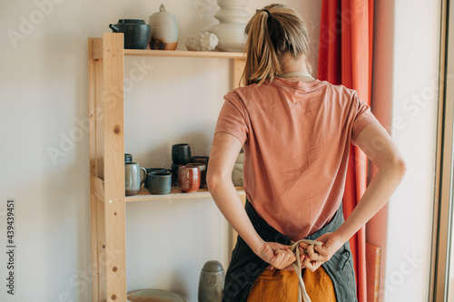 Woman tying an apron before work photo
