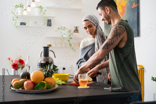 Muslim couple preparing healthy food and talking photo