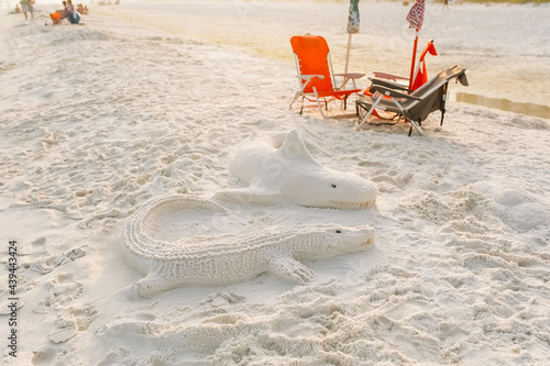 Handmade sand castles of a shark and crocodile.  photo