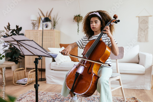 Hispanic cello student during music lesson at home