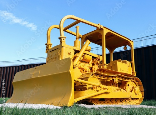 Close-up of a non-functioning bulldozer painted entirely in yellow paint