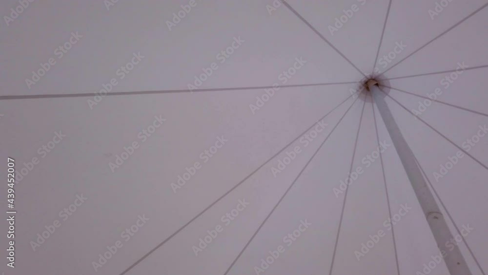 Umbrella in the form of a tent on the beach of the forest lake. Umbrella in the form of a tent on the beach of the forest lake.