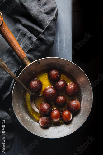 Indian dessert gulab jamuns in a pan photo