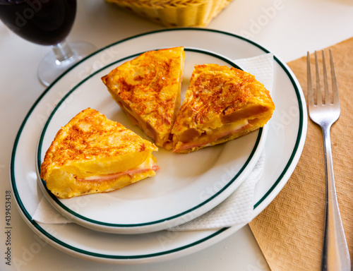 Appetizing tortilla with ham on a white plate