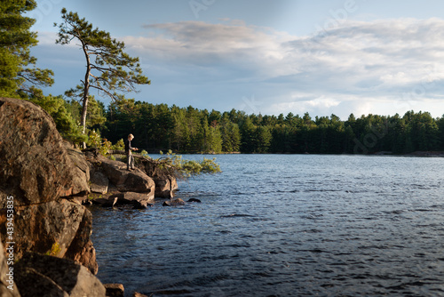 Wallpaper Mural Boy on Muskoka wilderness vacation fishes from shore of lake Torontodigital.ca