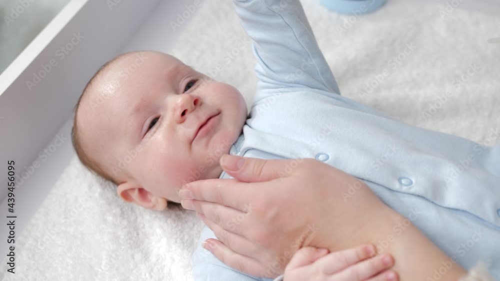 Mother's hand gently touching her baby face. Concept of baby care, parenting and family happiness Mother's hand gently touching her baby face. Concept of baby care, parenting and family happiness