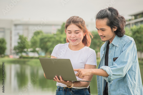 Asian people friendship using laptop computer technology outdoor