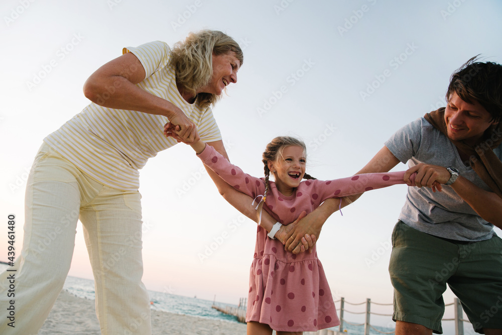 A girl with her father and grandmother on the beach A girl with her father and grandmother on the beach