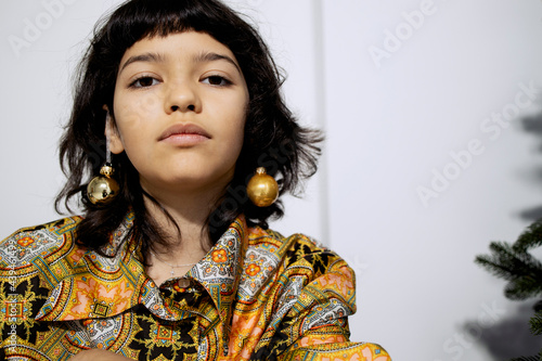 Fashionble girl  on a couch near a Christmas tree in a studio photo