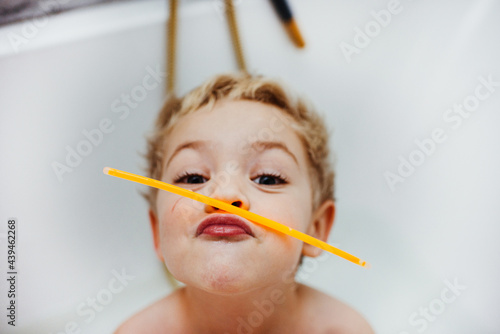Boy playing with glow sticks in the bath tub photo