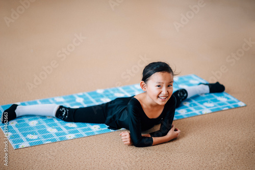 Little girl is engaged in rhythmic gymnastics in the gym
