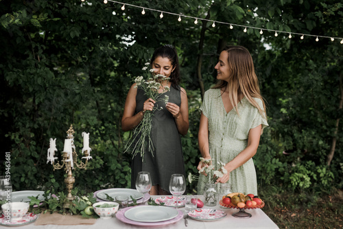 Young Women Arranging Flowers for Backyard Dinner photo