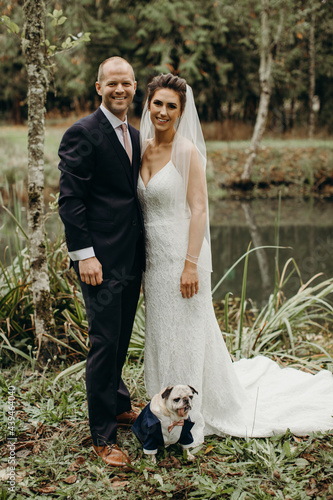 Portrait of Happy Couple and their Dog on Wedding Day photo