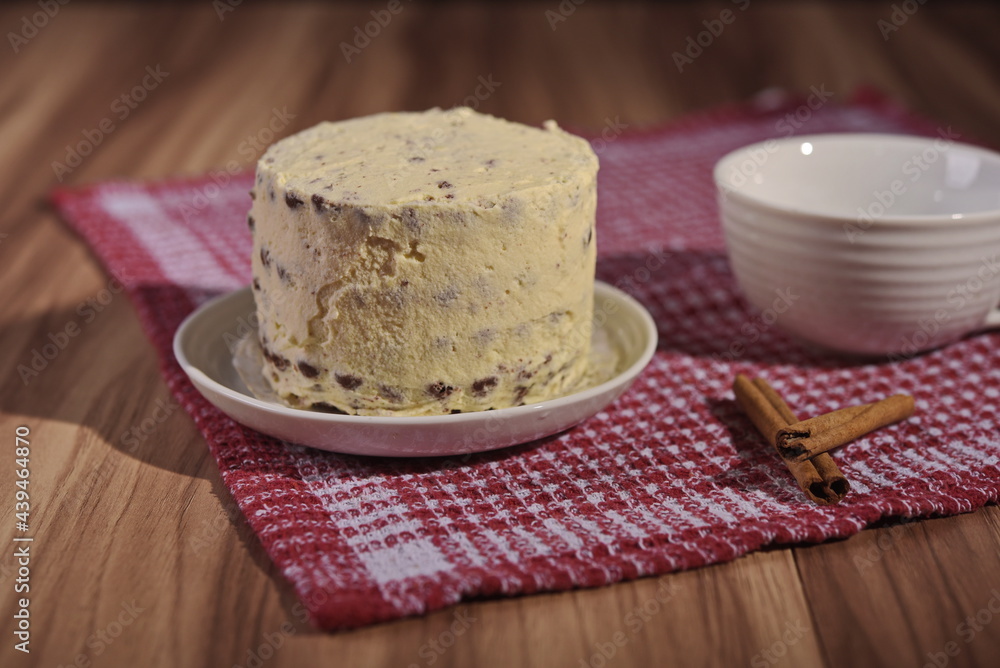 A buttercream cake and a cup of coffee with cinnamon sticks. A buttercream cake and a cup of coffee with cinnamon sticks.