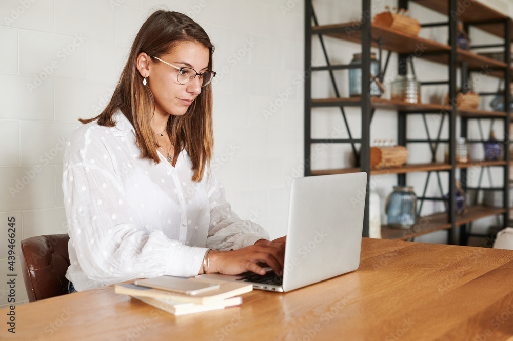 Young woman working on a laptop at home Young woman working on a laptop at home