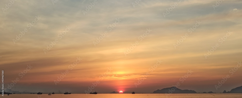 sea horizon sunrise with silhouette of ships and islands