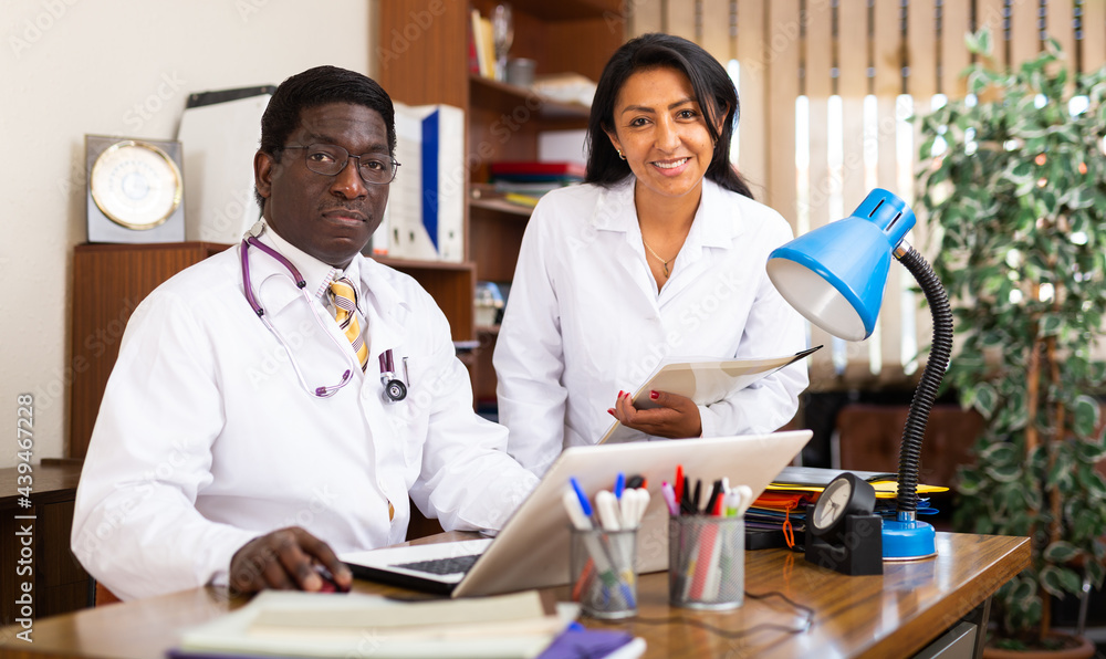 Fototapeta premium Male doctor and female nurse having productive day in office