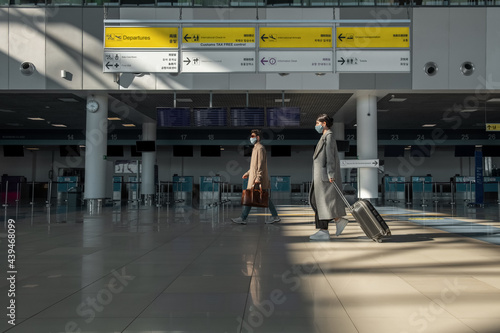 Wallpaper Mural Male and female travelers walking in airport terminal Torontodigital.ca