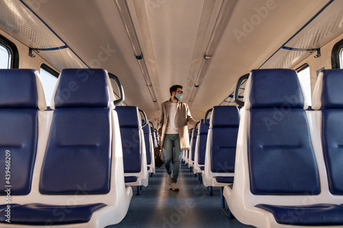 Male passenger walking in train aisle