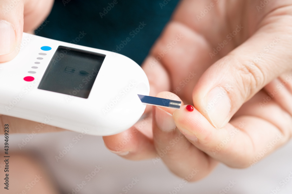 hand of people check diabetes and high blood glucose monitor with digital pressure gauge. Healthcare and Medical concept hand of people check diabetes and high blood glucose monitor with digital pressure gauge. Healthcare and Medical concept
