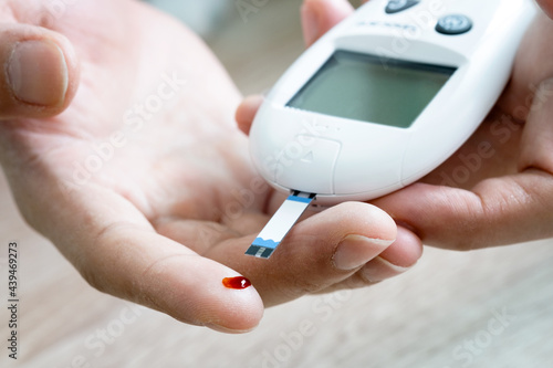 hand of people check diabetes and high blood glucose monitor with digital pressure gauge. Healthcare and Medical concept