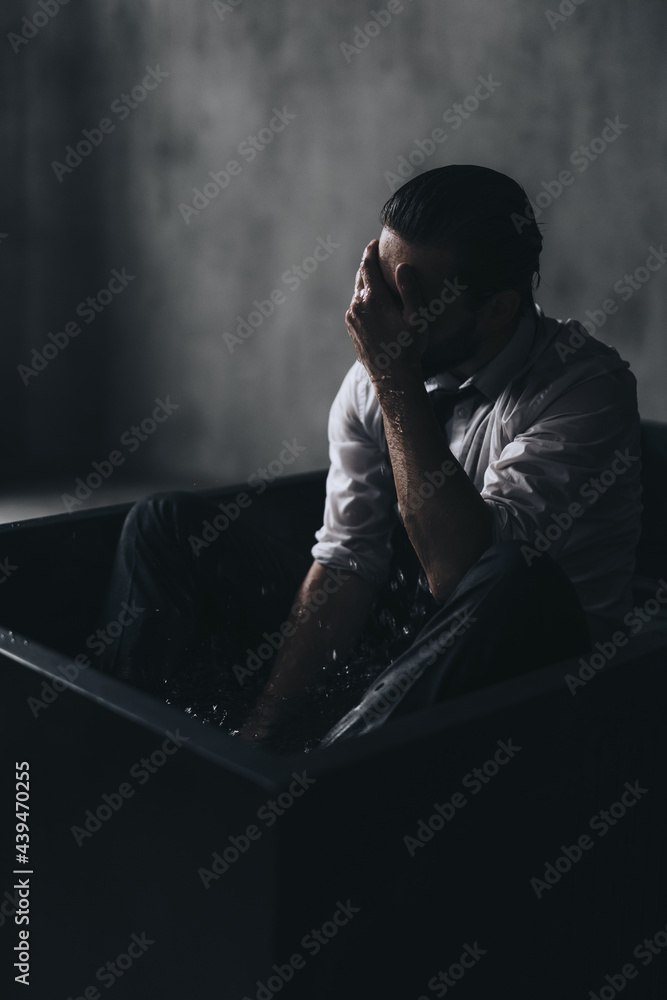 Upset man inside in dark studio Upset man inside in dark studio
