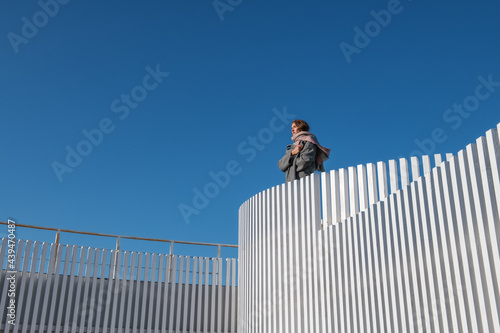 Woman in outerwear resting on top of building photo