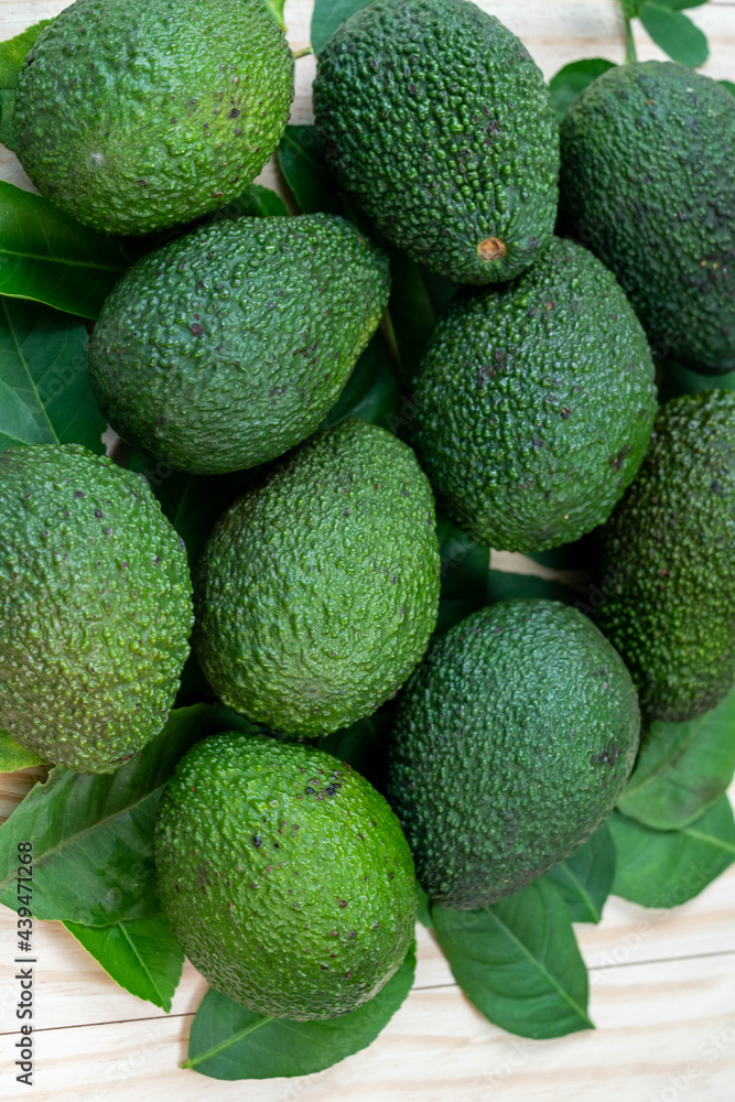 Avocado fruit with leaves on wooden background. Avocado fruit with leaves on wooden background.