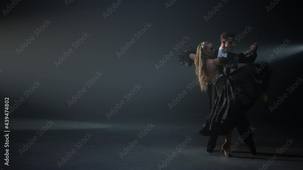 Ballroom dance couple performing indoors. Passionate dancers moving on stage. Ballroom dance couple performing indoors. Passionate dancers moving on stage.