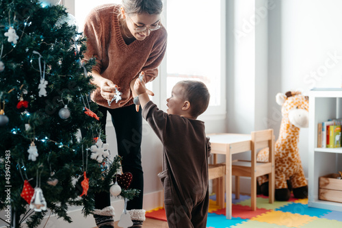 Mother and baby decorating Christmas tree photo