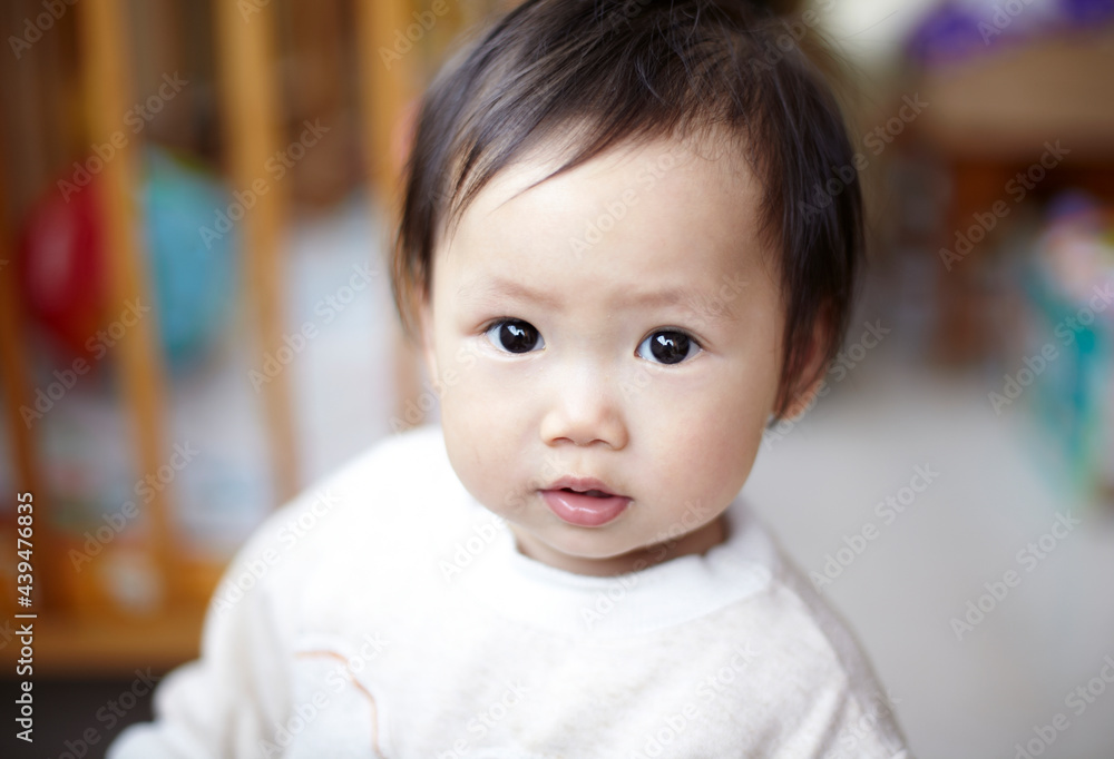 Cute Asian kid playing with comb at home Cute Asian kid playing with comb at home