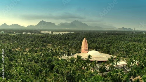 Drone view of a temple in beautiful green landscape with moutains in the back