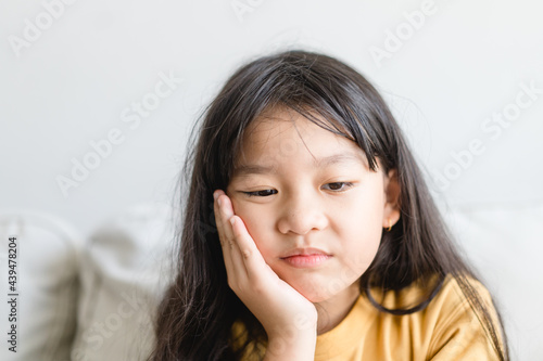 Asian kid girl toothache.kid suffering from toothache.TMD and TMJ healthcare Joint and Muscle Disorder.Asian child hand on cheek face as suffering from facial pain, mumps toothache.Dental health care.