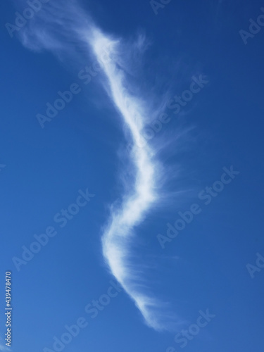 Stream of white wispy clouds in blue autumn sky photo