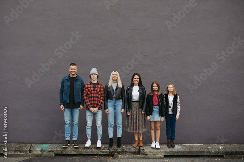 Family lined up against wall in order of tallest to shortest. photo