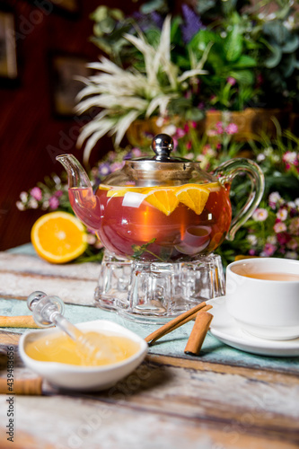 transparent kettle with fruit tea, honey with cinnamon.